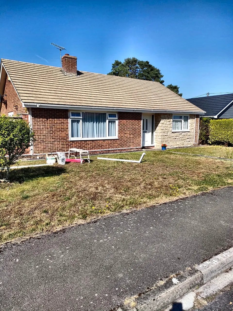 Brick bungalow with a tiled roof before the rendering work began
