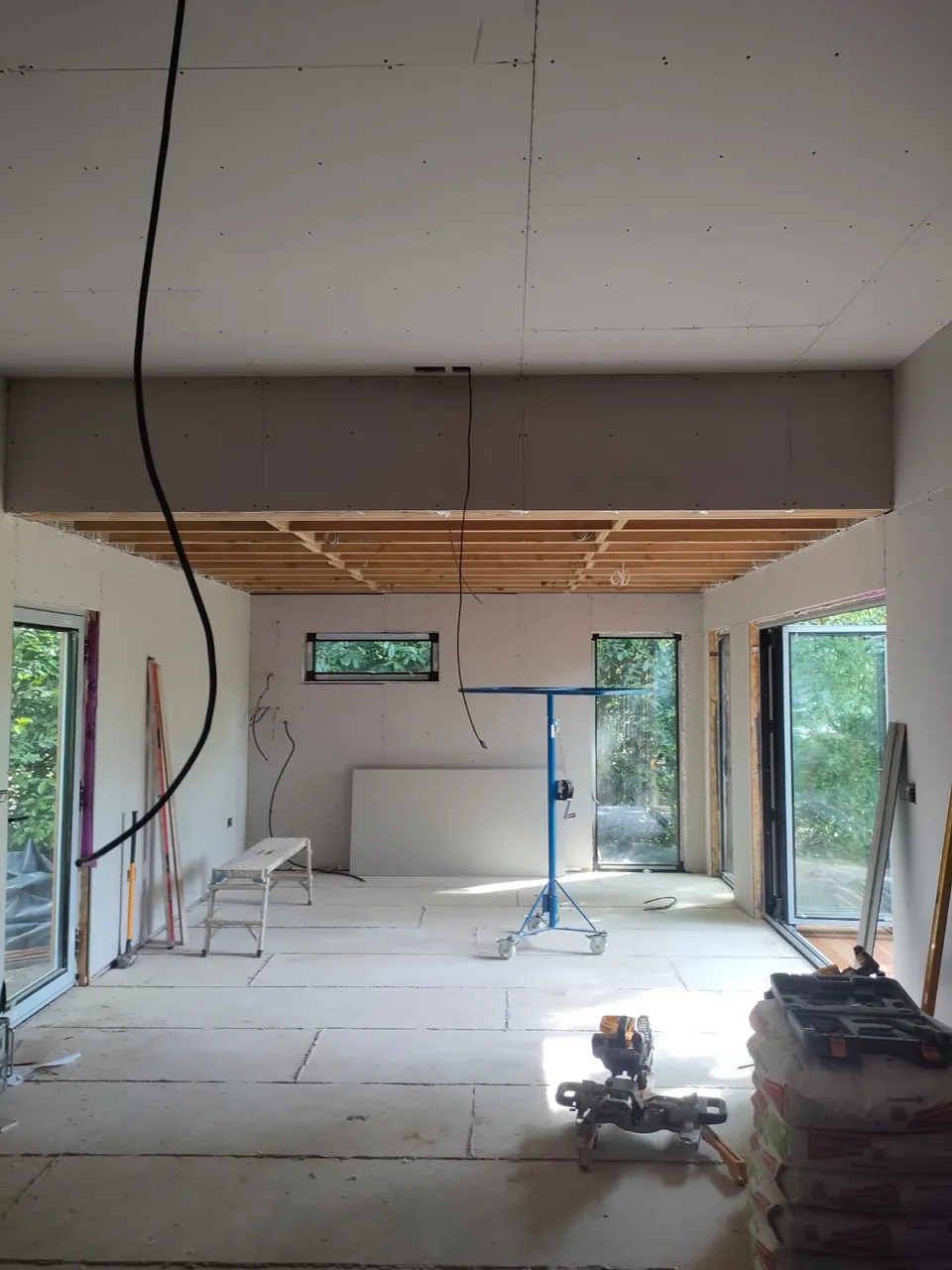Plasterboarded room with the ceiling and walls boarded and bifold doors on both sides
