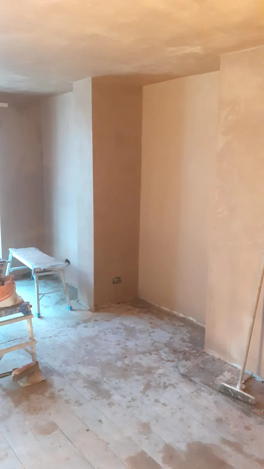 Newly plastered walls and ceiling with chimney breast alcoves in a renovated room
